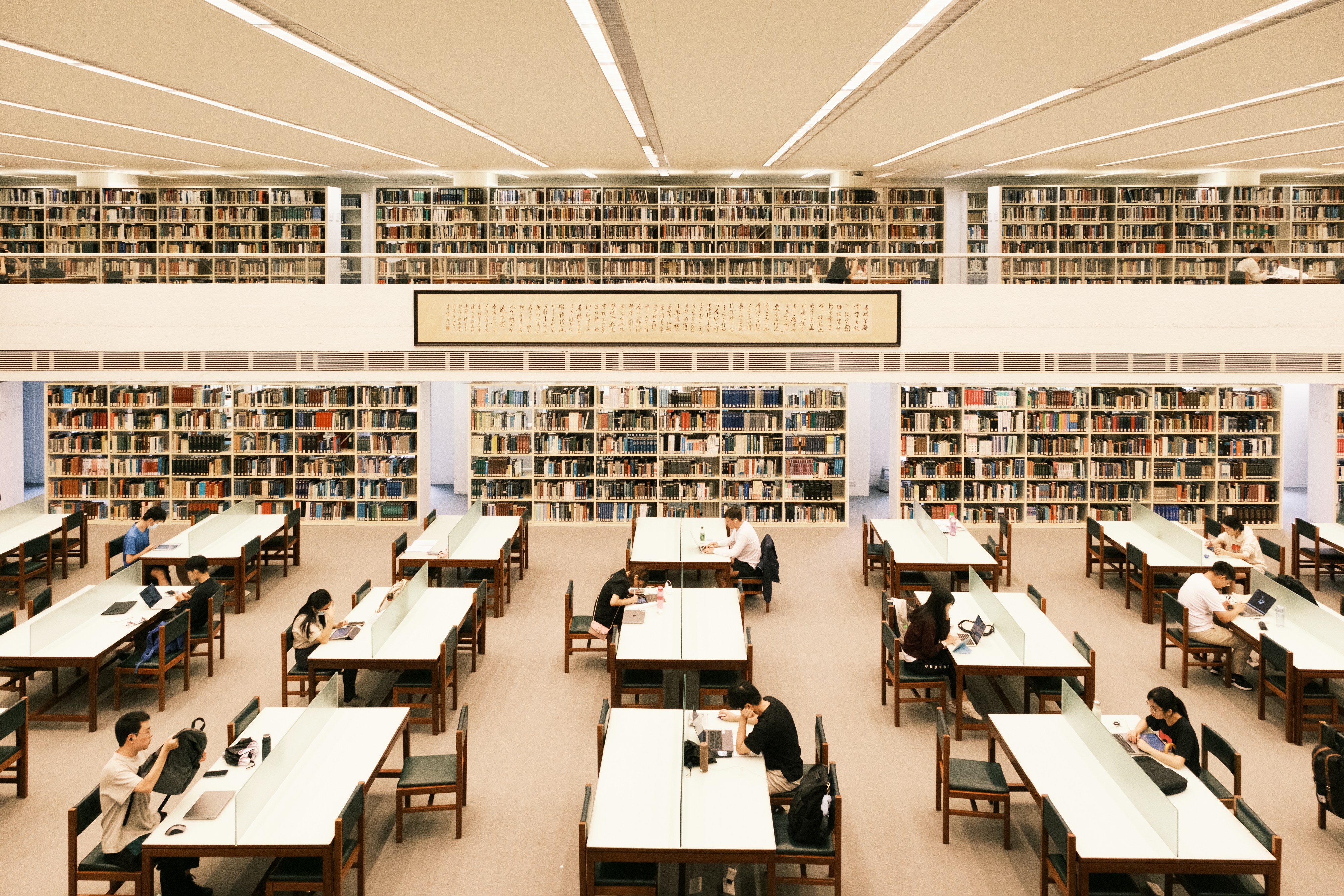 Modern library reading hall with rows of study desks — verifying official Sarkari exam information